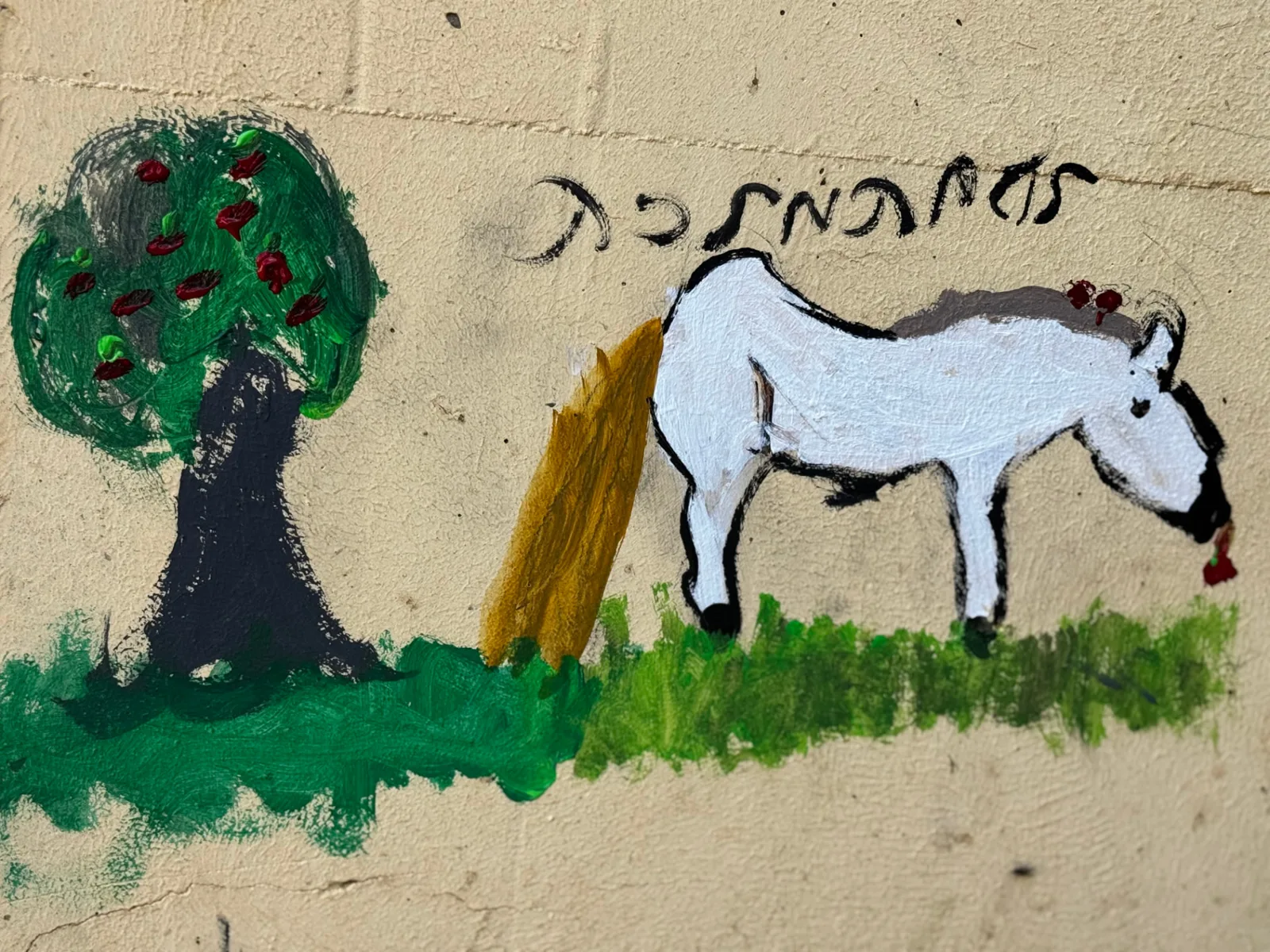 A painting of a white horse and a tree on a farm wall